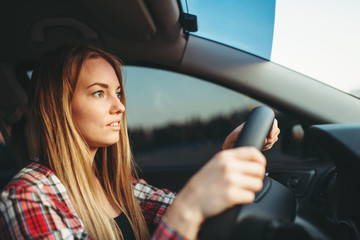 Fototapeta na wymiar Young woman beginner driving a car, back view
