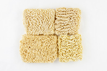 Different Asian raw dried egg noodles on white background