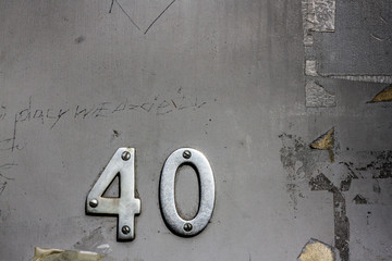 House number forty an a run down dilapidated door covered with scratches and graffiti