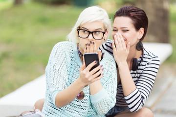Young happy female students outdoors in campus having a good time
