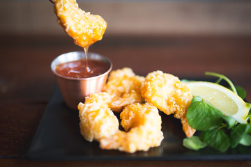 Dipping battered prawn in to sweet chilli sauce