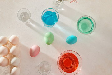 Easter eggs dyeing in glass with colors