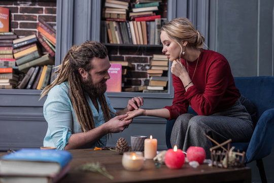 Nice bearded man touching a young womans hand