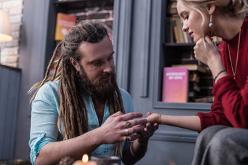 Positive bearded man working as a chiromancer