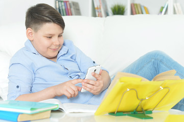 Portrait of young boy with smartphone playing the game
