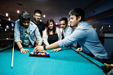 Group of stylish asian friends wear on jeans playing pool billiard on bar. - obrazy, fototapety, plakaty