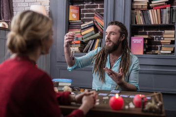 Positive bearded man presenting a special amulet