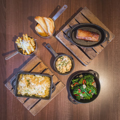Selection of dishes displayed in pans on wooden table