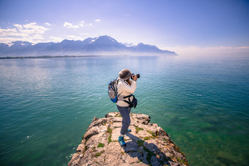 Fototapeta na wymiar Lady Photographer with lake Geneva and mountain landscape - Veytaux, Switzerland