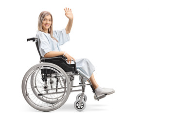 Smiling female patient in a wheelchair waving at the camera