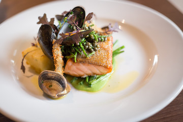 Salmon and seafood dish with potatoes and greens