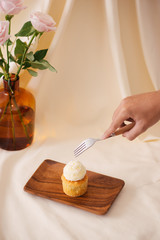 Female hands cut the delicious cupcakes on table