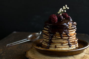 Homemade Pancake with raspberries and chocolate on a black background