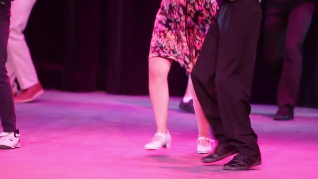 Close up to dancers feet dancing rock and roll, head silhouettes