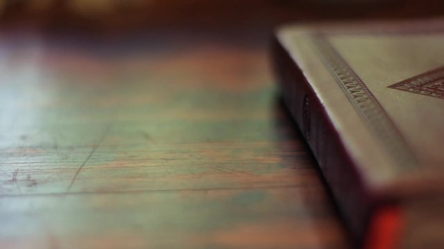 Pan over Bible sitting on table. Christian Bible reading.