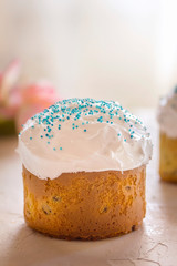 Festive Easter cakes on wooden white background surrounded by tulip flowers