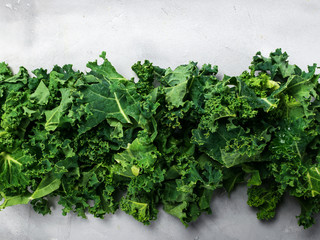 Fresh organic green kale background banner selective focus, top view, copy space. Green texture.