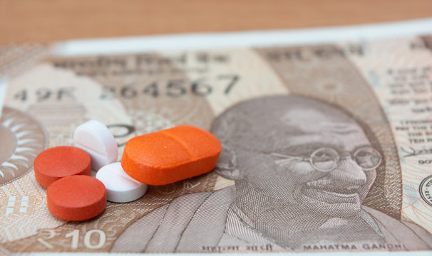 Concept of the affordable medicine in India due to generic drugs on Indian currency notes as background.