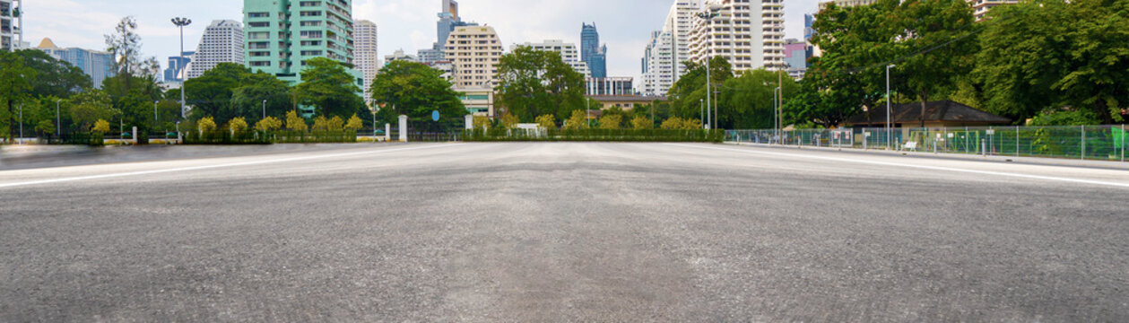 Empty asphalt road with city in the background