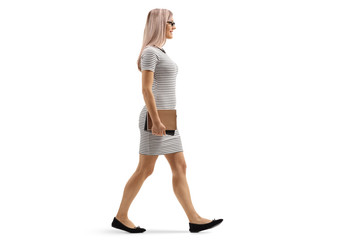 Young blond woman walking and holding books