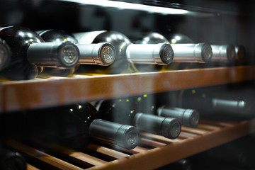 Storing bottles of wine in fridge. Alcoholic card in restaurant. Cooling and preserving wine.