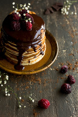Vegan pancakes with chocolate sauce and raspberries