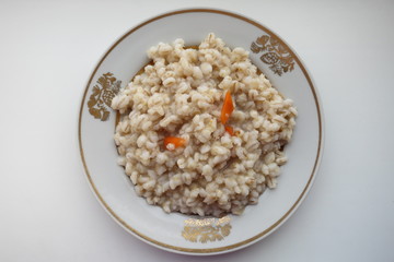 barley porridge with carrots in a white bowl