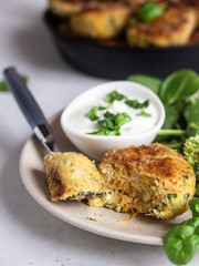 Delicious fried meat cutlets. Chicken or turkey cutlets with carrot and spinach served with broccoli, spinach and sour cream sauce. Light grey concrete background.