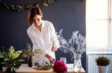 Young creative woman in a flower shop. A startup of florist business.