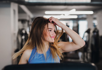 A portrait of young girl or woman doing cardio workout in a gym.