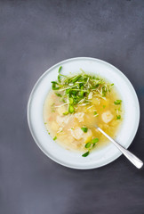 cauliflower soup with chicken fillet in a bowl, with herbs, greens on concrete background Top view with copy space.