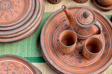 Top view closeup of beautiful Gujarati Khavda Pottery earthen terracotta crockery tea cups kettle and tray at a roadside market exhibition stall at Dilli Haat, New Delhi India International trade fair