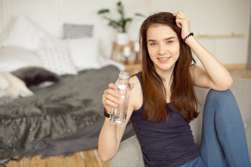 Sports girl with dark hair holding bottle of clear water healthy food, healthy lifestyle