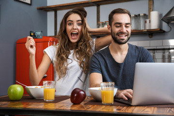 Cheerfuly young couple shopping with laptop