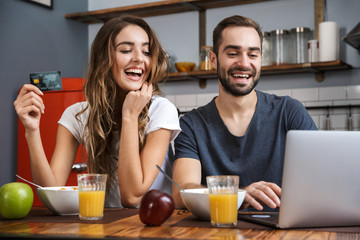 Cheerfuly young couple shopping with laptop