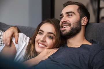 Cheerful young couple relaxing on couch
