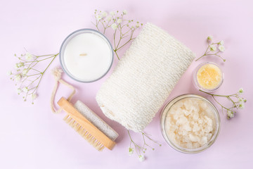 SPA concept - towel, salt, candle on pink background, copy space
