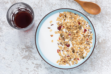 Granola, oatmeal with milk, honey and strawberry on blue plate