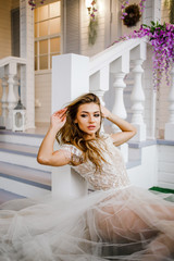 Fototapeta premium Elegant bride in a white dress sitting in the wedding hall