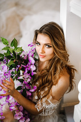 Portrait of a elegant girl with purple flowers in her hands