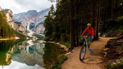 Tourist cycling in Cortina d'Ampezzo, stunning rocky mountains on the background. Man riding MTB enduro flow trail. South Tyrol province of Italy, Dolomites.