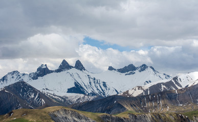 mountain peaks in spring and cloudy sky