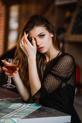Amazing blonde holds a glass of cognac in her hand