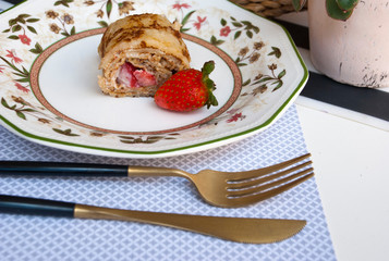 Chef dessert pancakes rolls with strawberry. Food photo.