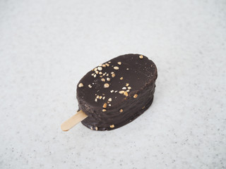 delicious ice cream eskimo on a stick covered with chocolate lies on a marble table