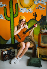 Fototapeta na wymiar Beautiful hippie girl holding a guitar in her arms