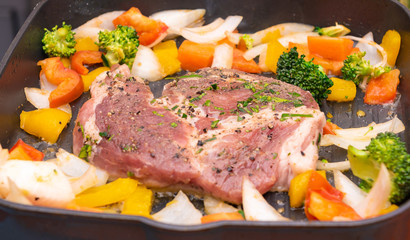 Cooking fried pork steak with colorful pepper and onion