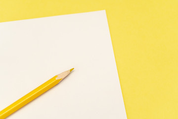 Close-up of yellow pencil on the white and yellow background.