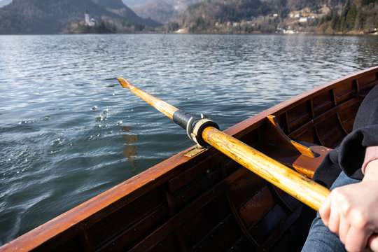 Young woman using paddle on a wooden boat - Lake Bled Slovenia rowing on wooden boats
