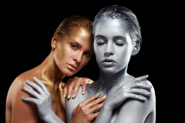 Beauty portrait of young gorgeous women. Golden and silver girls on black background